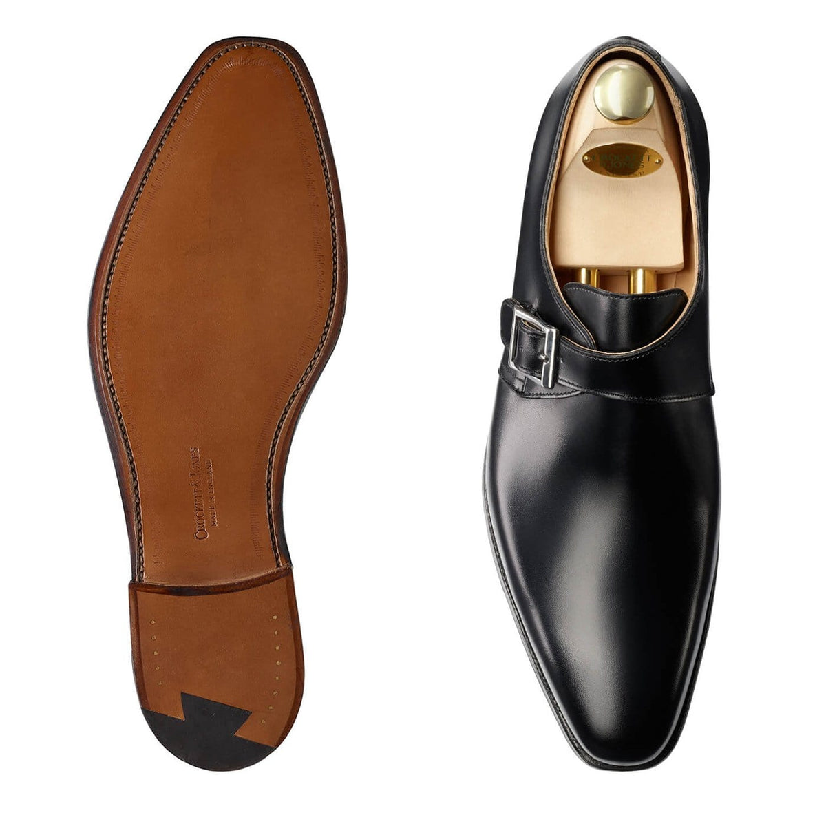 Black leather dress shoe with gold interior and brown sole on a white background