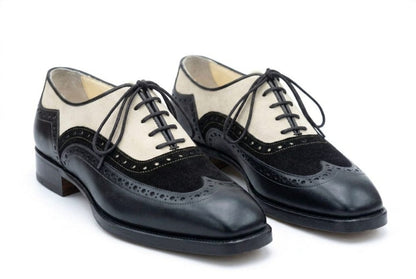 Black and white shoes with a wingtip design on a white background